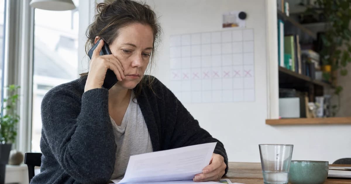 Een werknemer die zich telefonisch ziek meldt naast een kalender, arbeidscontract en re-integratieplan